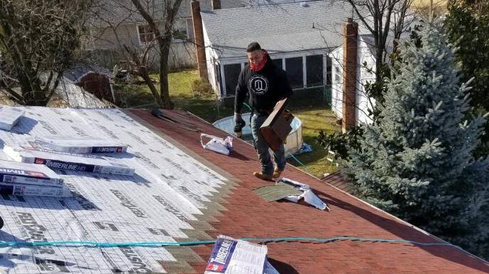 man working on roof - roofing materials